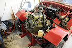 The renovated engine being put back into the car.