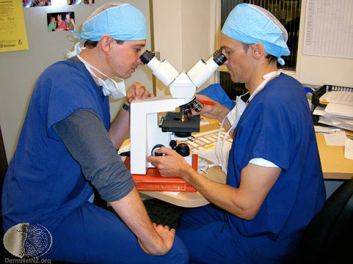 Surgeons examining skin tissue - Click to visit DermNet NZ