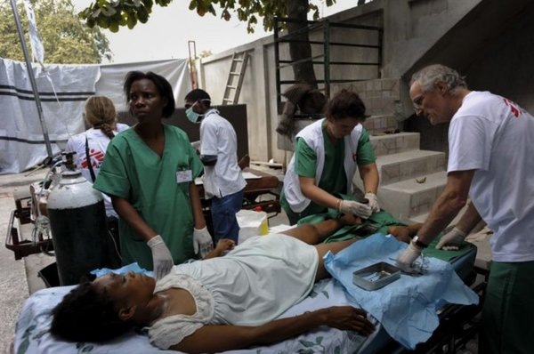 [A #Haitian doctor, UK surgeon, and German nurse treat a patient with two broken legs. © Julie Remy[5].jpg]