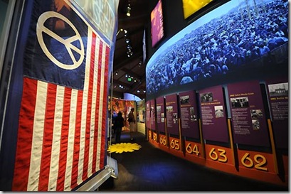 La cronologia degli anni Sessanta e una bandiera Usa con il simbolo della pace Afp