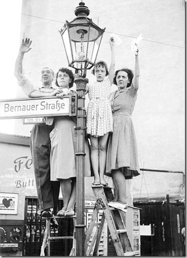 Jung, Abitanti della Germania Ovest salutano i parenti che vivono oltre il Muro, nel settore Est di Berlino, 1961 - © Jung - Ullstein Bild - Archivi Alinari