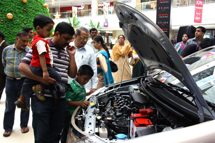 Entire family checking out Etios Car engine