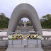 The Cenotaph for the A-Bomb Victims, with the a-bomb dome in the background.  Copy-paste: The Cenotaph is an arched tomb for those who died because of the bomb, either because of the initial blast or exposure to radiation. Below the arch is a stone chest holding a register of these names, of which there are over 220,000.