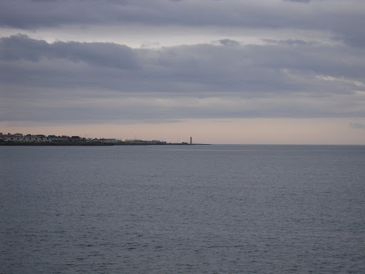 Early evening, looking out west from the city. That lighthouse is the westernmost object on the peninsula that holds Reykjavík.