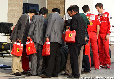 люди в пиджаках с пакетами Ferrari и Роб Смедли на Гран-при Кореи 2010