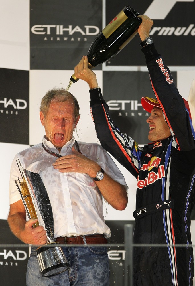 Себастьян Феттель поливает Хельмута Марко шампанским на подиуме Гран-при Абу-Даби 2010