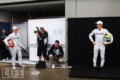 фотограф снимает Михаэля Шумахера в это время Нико Росберг стоит в сторонке на Гран-при Австралии 2011
