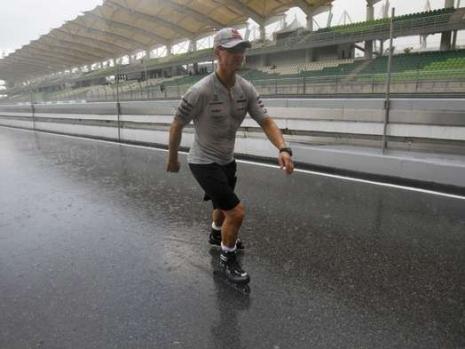 Михаэль Шумахер едет по пит-лейну на роликовых коньках на Гран-при Малайзии 2011