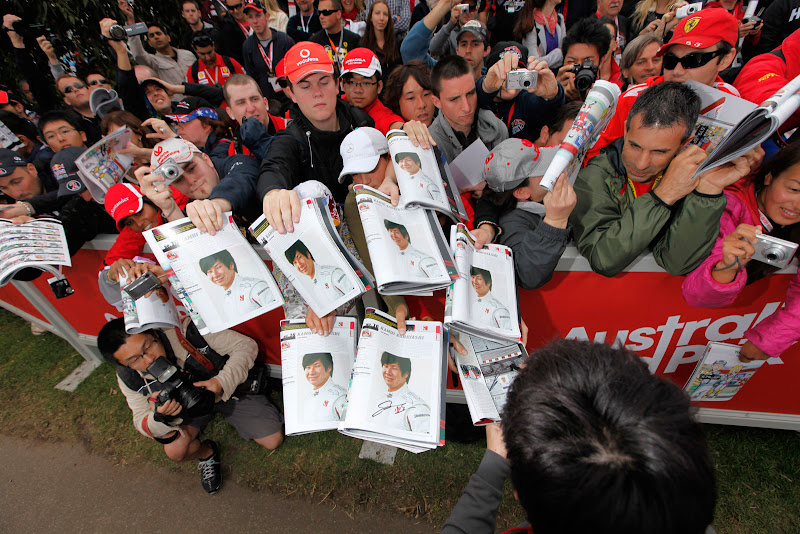 Камуи Кобаяши подписывает журналы со своим фото болельщикам Альберт-Парка на Гран-при Австралии 2011
