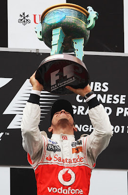 Льюис Хэмилтон наслаждается победным кубком на подиуме Гран-при Китая 2011