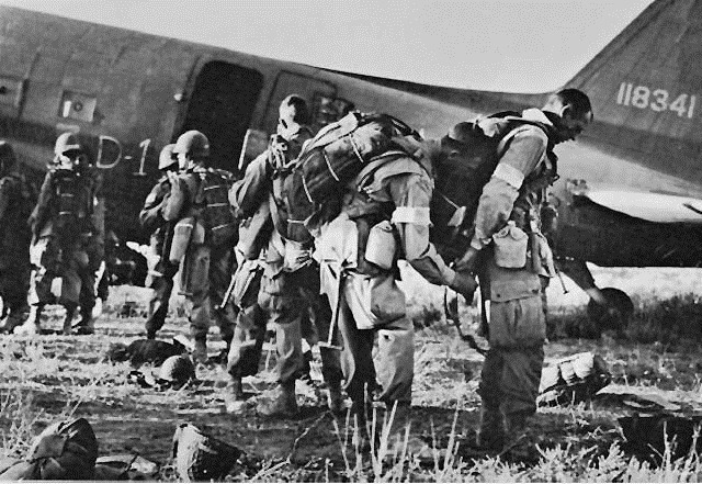 [PARATROOPERS, IDENTIFIED BY WHITE ARM BANDS, preparing to emplane for Sicily.[7].jpg]