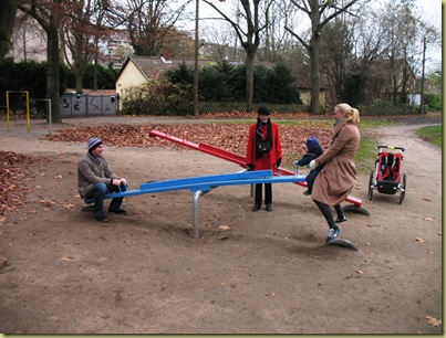 M L and parents on the blue seesaw