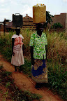Acholi women carrying 20 litre water containers from a nearby well