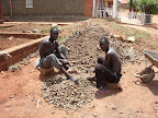 Workmen breaking rocks with hammers to make concreting gravel