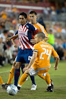 Sergio Santana peleando el balón contra jugadores del Dynamo