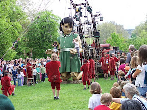 The little girl kneeling down with kids swinging on her arms