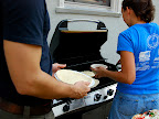 Genny worked hard out on the grill, grilling the pizzas