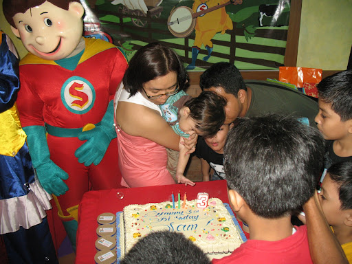 Blowing Sam's bday cake.