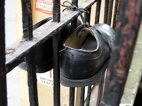 We sat on someone's front steps to eat our food. These shoes were hanging like this on the railing to our right.