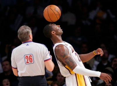 Los Angeles Lakers guard Kobe Bryant (24) bounces the ball on his head during a break in the game as referee Bob Delaney looks on during the second half of their NBA basketball game, Sunday, Nov. 4, 2007, in Los Angeles. The Lakers won 119-109. (AP Photo/Mark J. Terrill)