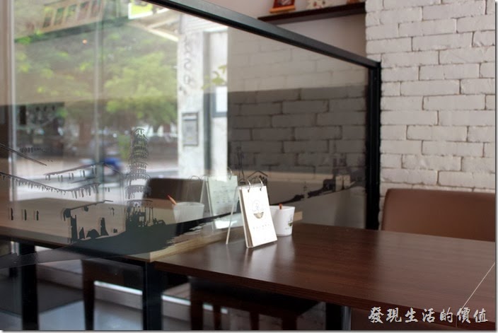 台南-綠帕克咖啡館。桌子與桌子間的隔牆則巧妙的利用後玻璃並貼上許多黑色的景物剪影，讓桌與桌之間有點距離又沒有距離。