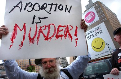Man hold sign reading 'Abortion is MURDER'