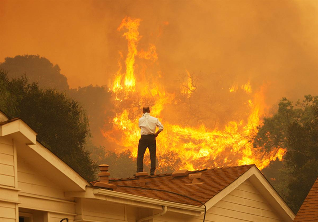 A man looks at approaching flames as the Springs Fire continues to grow on 3 May 2013, near Camarillo, California. The wildfire spread to more than 18,000 acres on day two and was only 20 percent contained Friday evening. Photo: NBC News