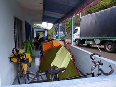 Five cyclists with three tents in a restaurant entrance.
