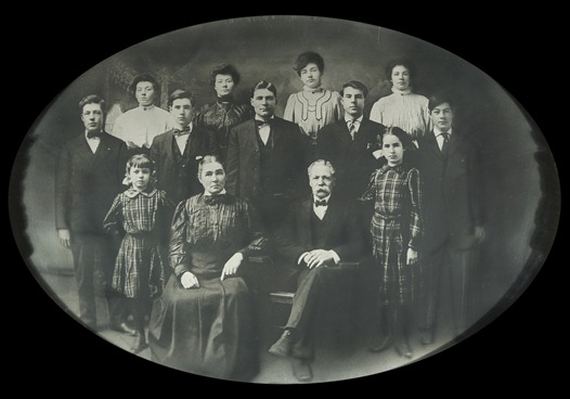 J W Lucore Family<br />This is an original portrait of John Wesley Lucore and Martha Arvilla Hevener and their 11 children. <br />Back row from the left-Mant, Alice, Minnie, Belle. <br />Middle row-Roy, Lowell, Harp, Howard, Sim.<br />Front row-Rose, Grandma Lucore, Grandpa Lucore, Abbie.<br /> John Wesley served in the Civil War.