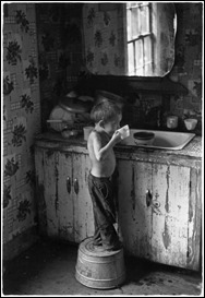 Small boy drinking water in his home in Kentucky, 1964