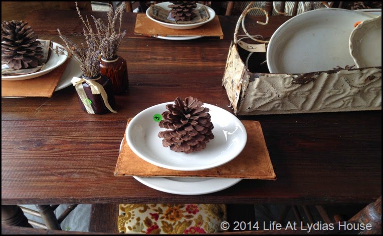 Round top table with pinecones and book backs via Life At Lydias House