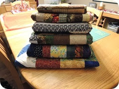 108.Stack of scraps quilts