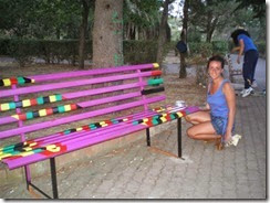 Una ragazza alle prese con la decorazione di una panchina (foto Caltagirone)