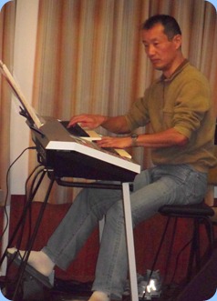 Takashi Iida playing his Yamaha Electone D-Deck two manual keyboard and 20-note pedalboard.