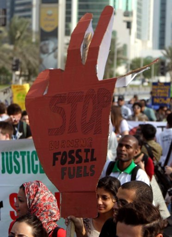 Activists carry placards during a rally in Doha, Qatar, 1 December 2012. Poor countries want the rich world commit to a new funding package from 2013 to help them cope with worsening drought, flood, storms and rising seas less.  Karim Jaafar / AFP