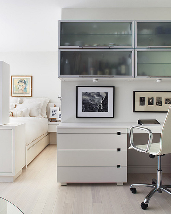Habitación blanca y luminosa de invitados con pequeña oficina
