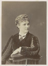 Studioportret van een vrouw, zittend op een stoel met halfronde rug