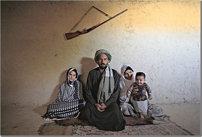 Portrait of Mohammed Fazal, 45, with his two wives (L-R) Majabin, 13, and Zalayha, 29 in the village on the outskirts of Mazar Al Sharif. Fazal was offered Majabin as a debt settlement when a fellow farmer could not pay after a night of playing cards. They have been married for six months. 
