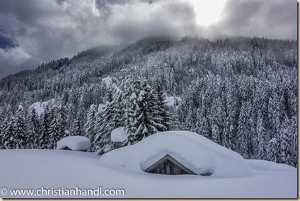 Holzhütte von viel Schnee bedeckt