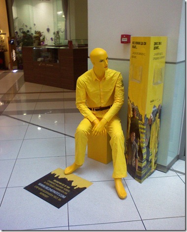 Жълт манекен, седнал до информационен щенд