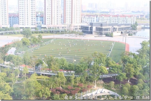 從瑞士酒店的高處往下望，可以看到運動場上有很多的民眾在場上踢足球。