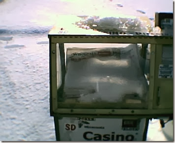 Snow in a Newspaper Box at a Minnesota Rest Area on December 20, 2003