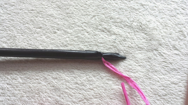 Stab mit Geschenkband, angebracht mit schwarzem Klebeband fester Stab mit Geschenkschnur, angebracht mit schwarzem Klebeband