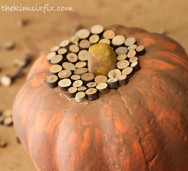 Gluing wood on pumpkin