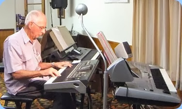 John Perkin playing his Korg Pa3X amidst an array of keyboards setup for the eveings entertainment. Photo courtesy of Dennis Lyons.