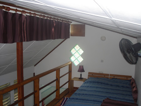 Interior cabanuta Lemongrass Lodge - patul la etaj, bucataria, holul si baia jos.JPG