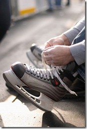 tying-laces-of-ice-hockey-skates-at-skating-rink