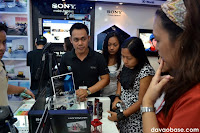 Bloggers and walk-in customers ask the salesperson about the new Sony Handycam with built-in projector