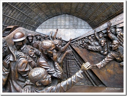 A statue depicting St Pancras station over the decades. The troops departing while injured comrades return.