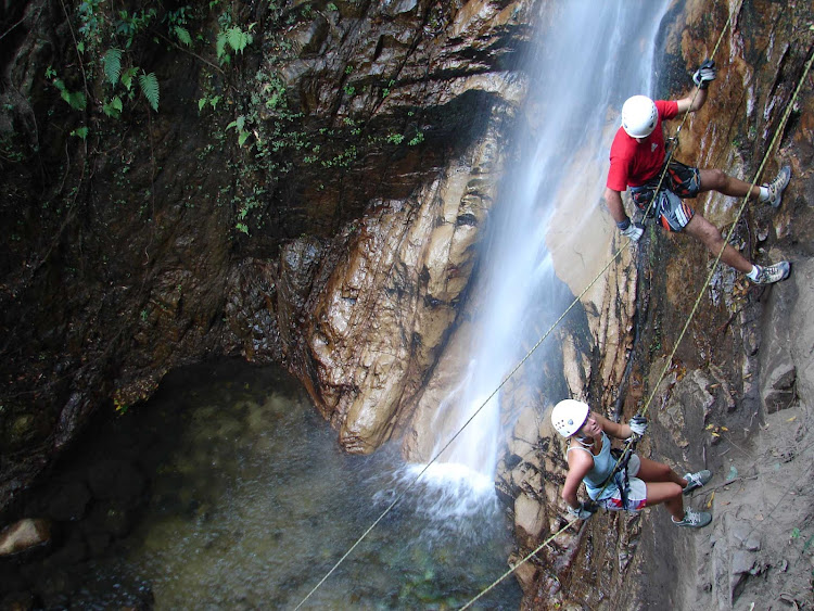 Guides help travelers rappel down a waterfall north of Puerto Vallarta, Mexico.